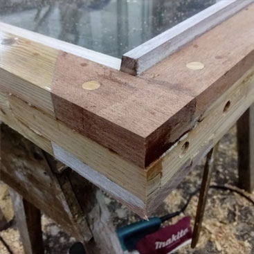 Close-up of a newly joined wooden window frame corner with dowels and layered timber
